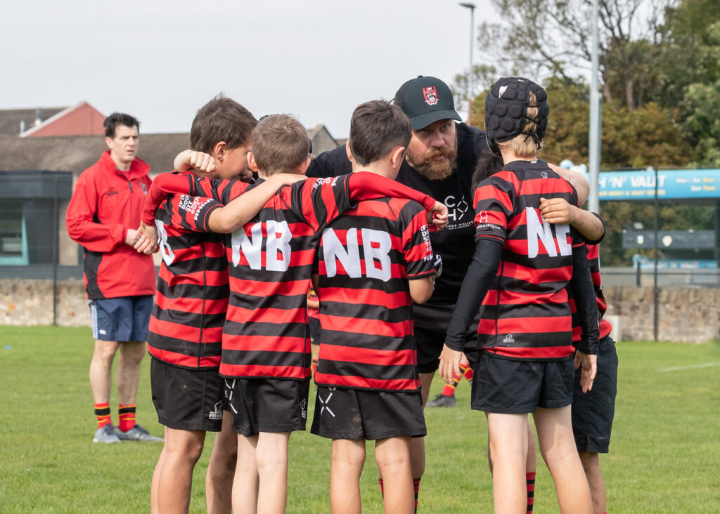 A rugby coach talking to his players